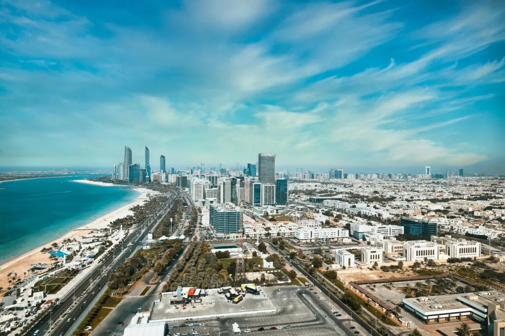 A breathtaking aerial view of Abu Dhabi's waterfront cityscape with modern high-rises and skyline.