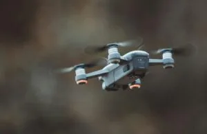 A detailed close-up of a drone flying in an outdoor setting, showcasing its design and technology.
